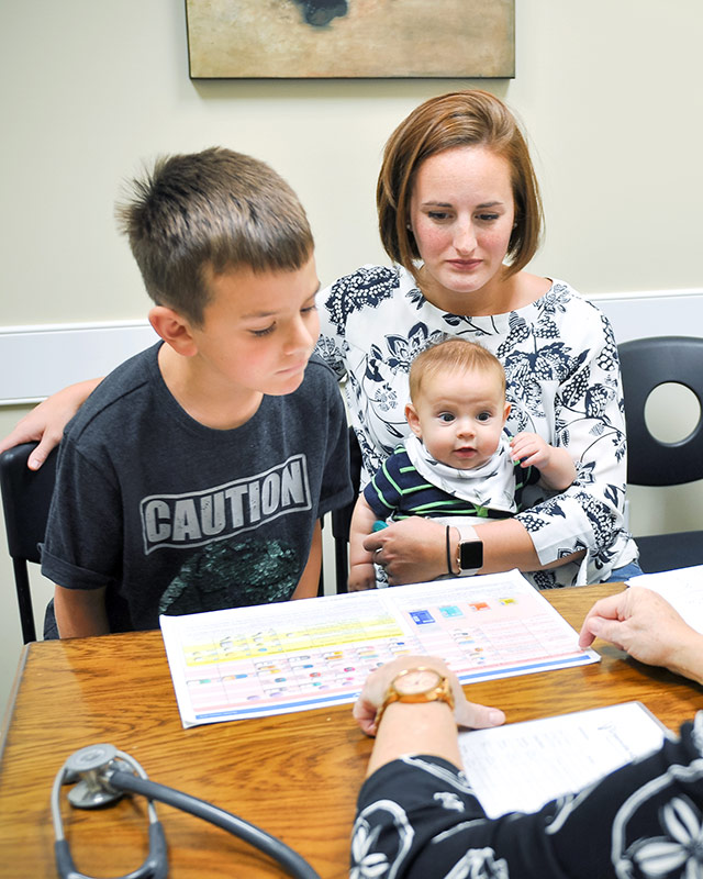 Mom with young ADHD son and baby learning about medications in Dr. Sheila Woods office at Greenville ADHD Specialists